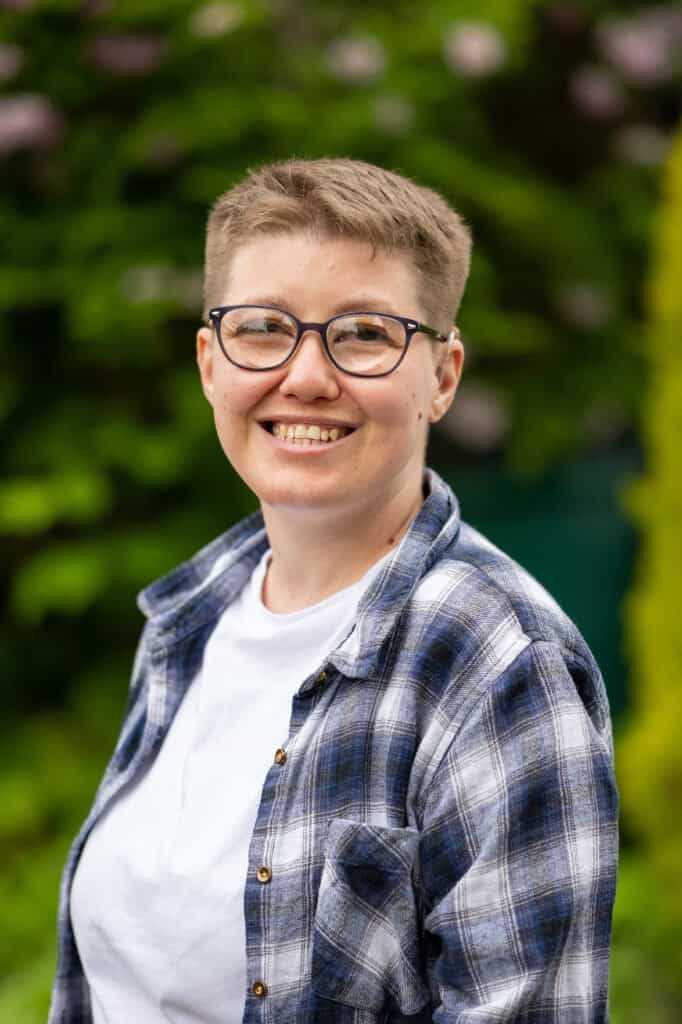 Emma Blackmore, a white woman with short hair and glasses, smiling at the camera.