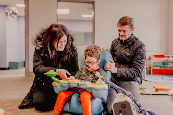 Two parents show their child a sensory toy at a Sense centre