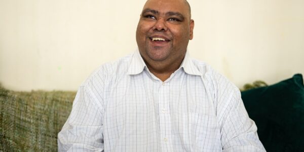 Mo, a smiling Asian man wearing a white shirt.