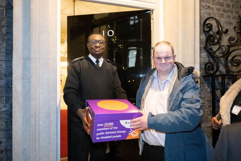 Steven handing in the Sense petition to an official at 10 Downing Street.