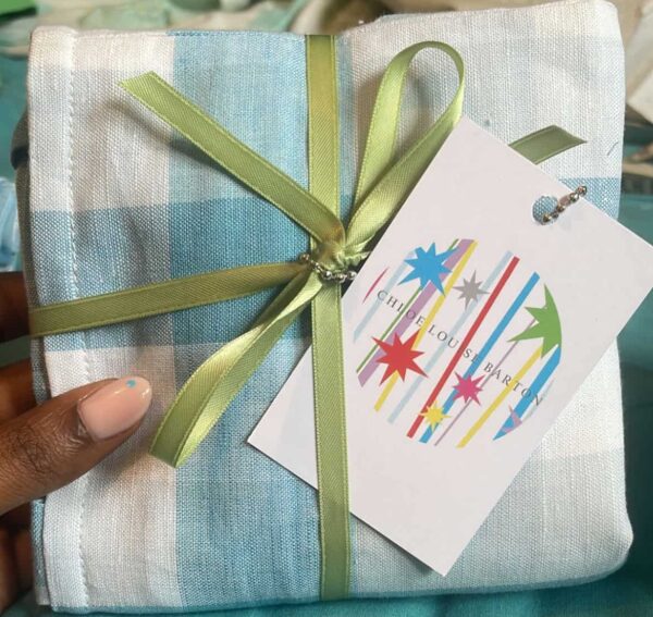 A blue and white tote bag, made by Chloe, wrapped up ready to give to her customers.