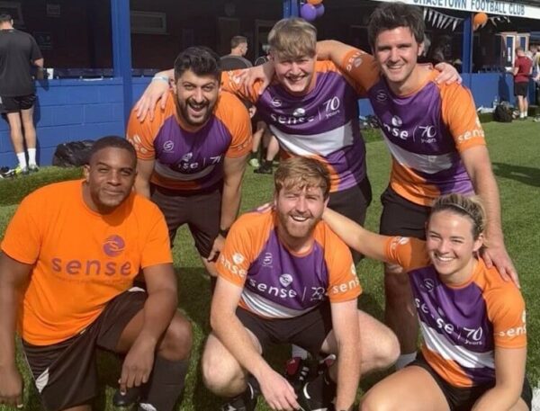 Sense staff posing in their orange branded tops before their football tournament.