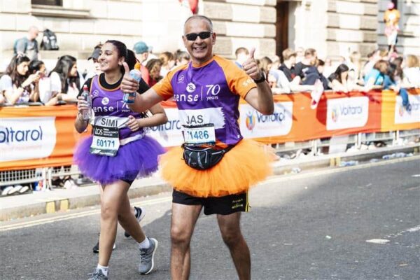 Two Sense Marathon runners fancy dressed in orange and purple skirts.
