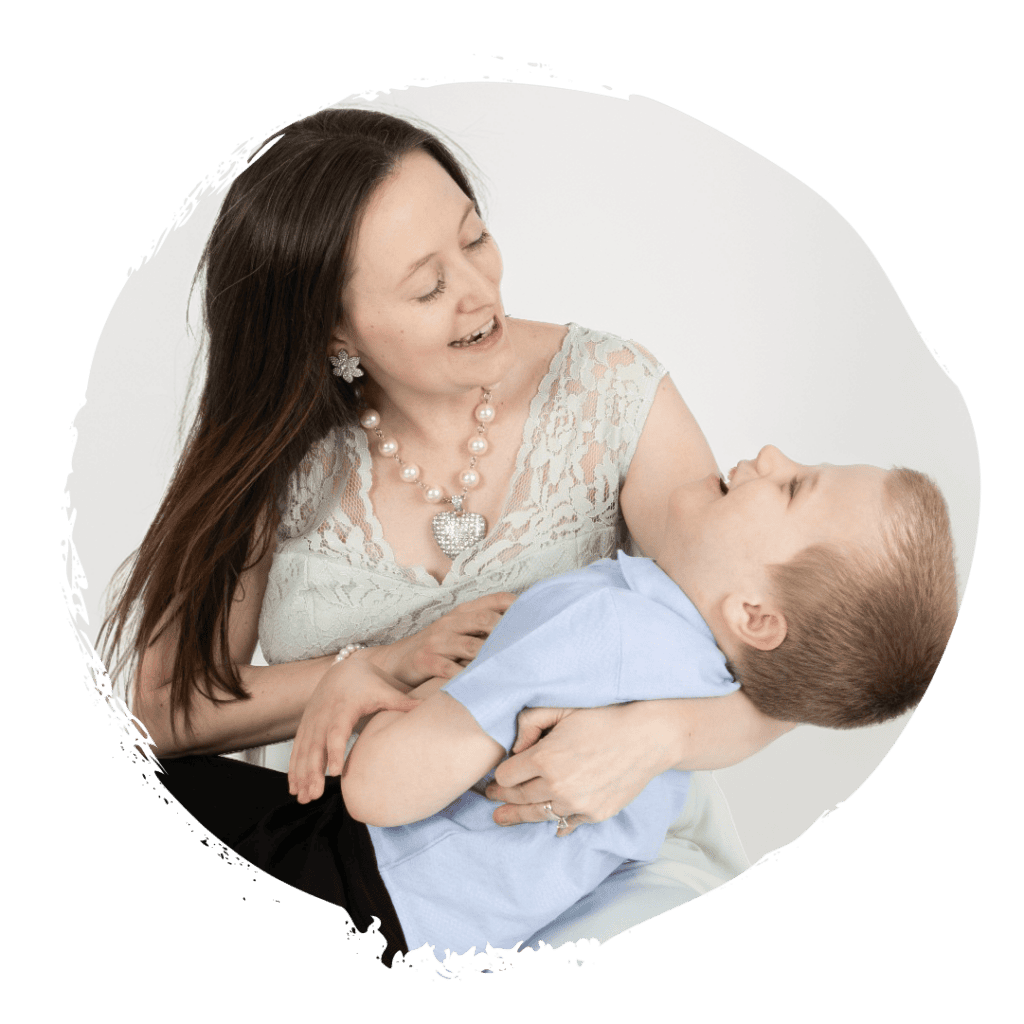 Kyllian, a small blonde boy, smiles in the arms of his mother
