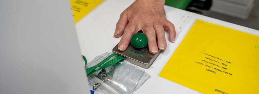 Joe's hand is hovering over a green buzzer.